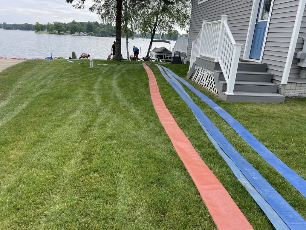 unrolling the hoses for the Sandpro system in preparation of a private beach installation on Wiggins lake in Gladwin MI.