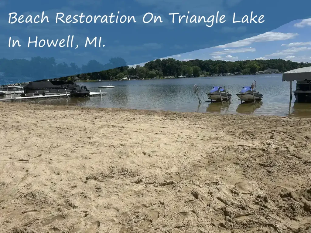 fully restored beach on Triangle lake in Howell, MI. with 2 jet skis on their docks above the water.