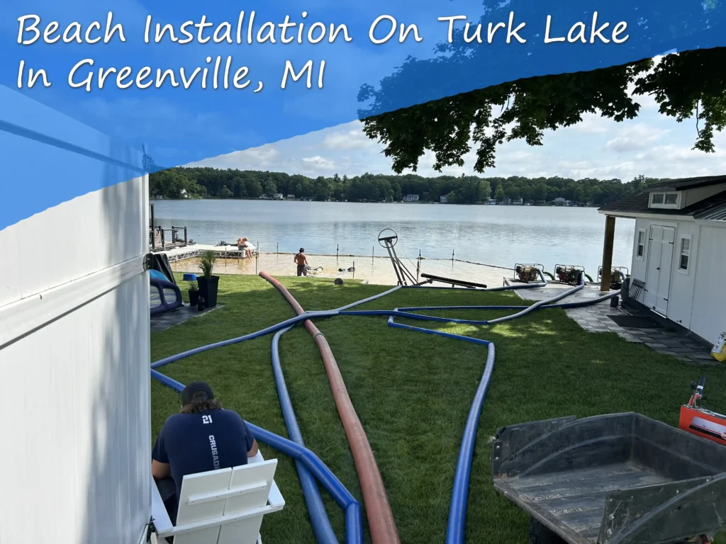 Beach sanding on Turk Lake in Greenville Michigan, hoses out, guys in the water working.